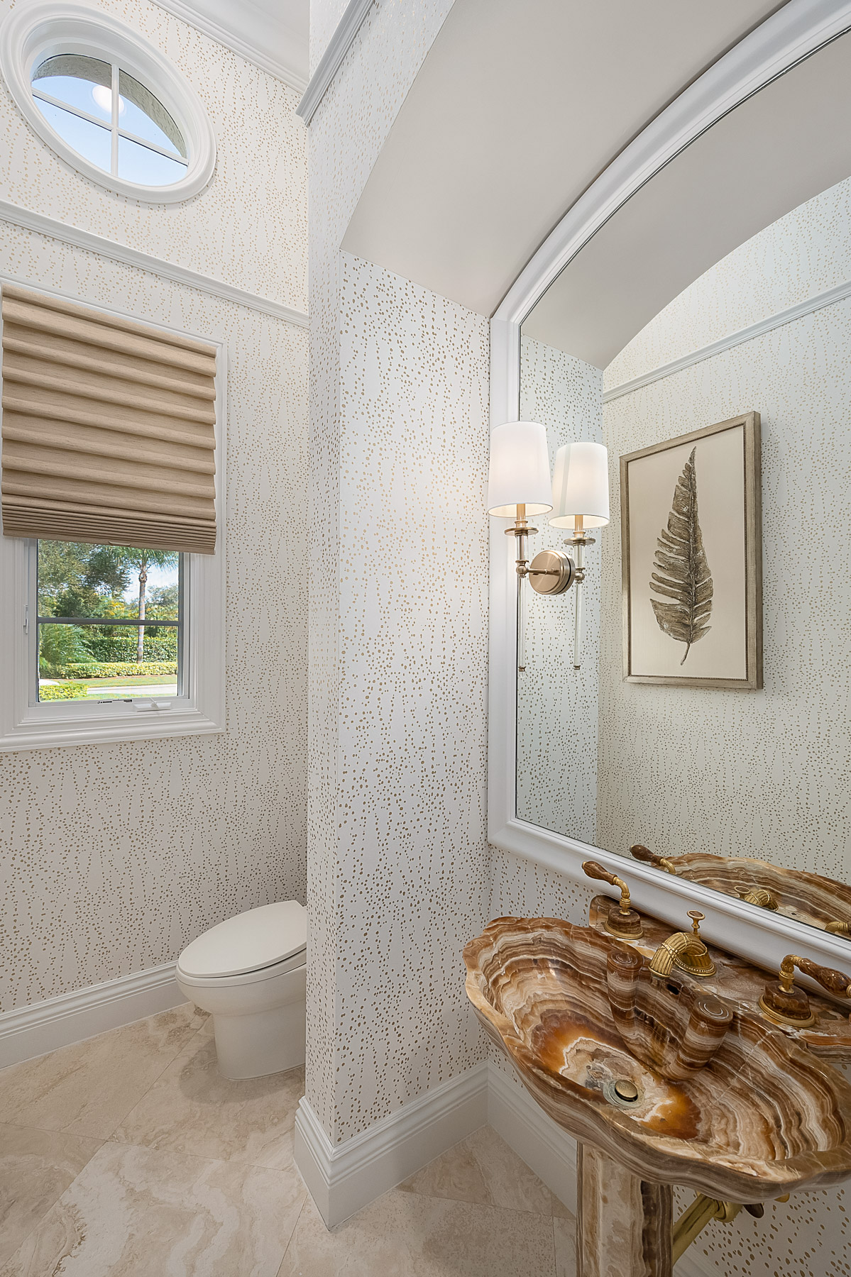 Powder bath features a custom onyx sink with gold fittings and accessories that provide glitz and glamour