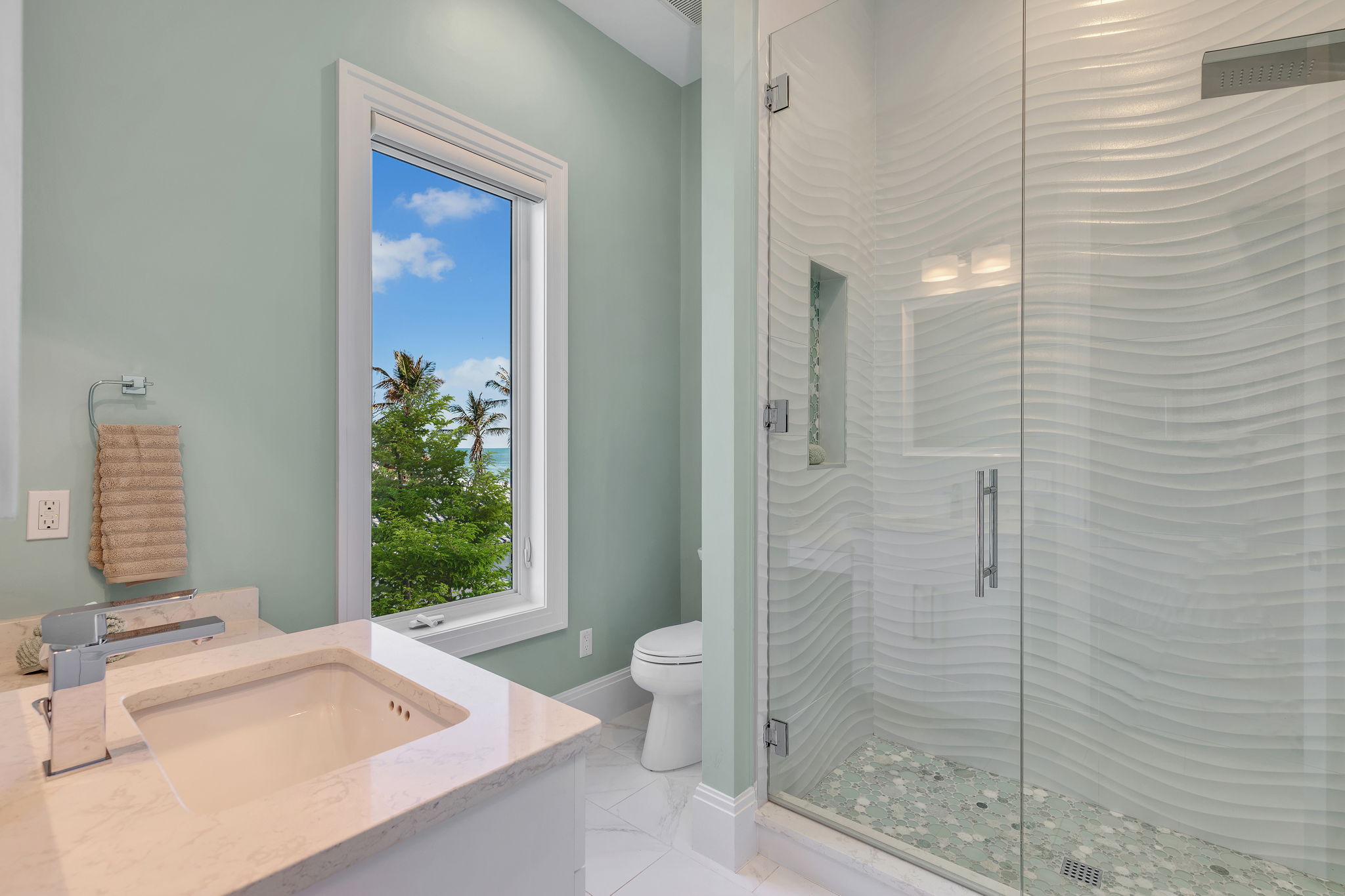The bathroom features a light green aqua palette